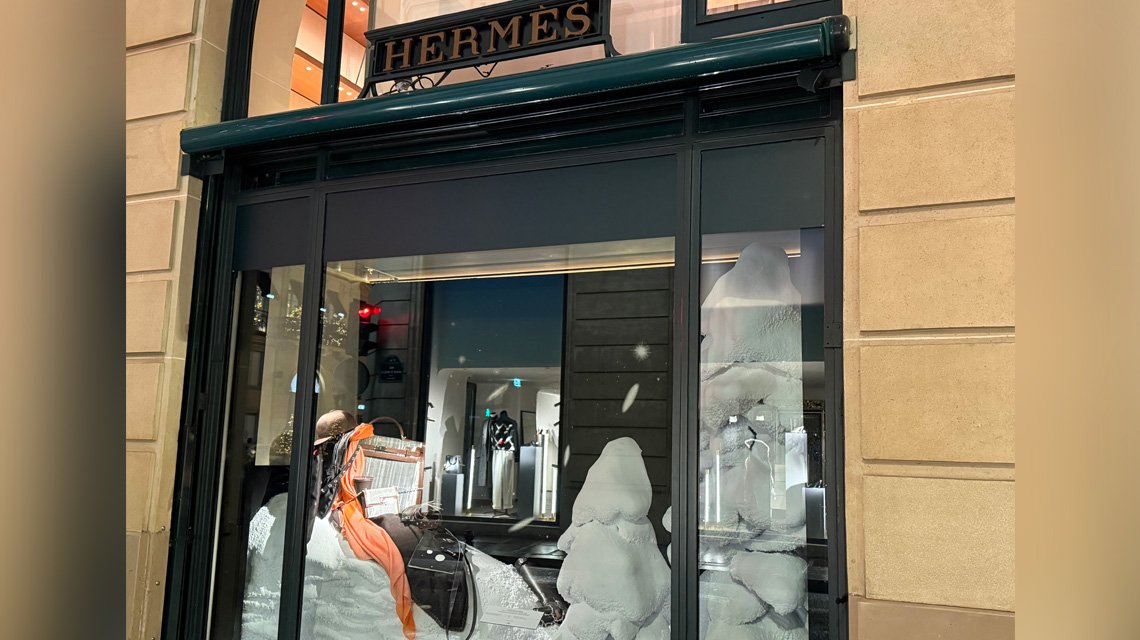 Cenografia Hermès – mala e écharpe com detalhes em malha metálica Aura Inox - <p>Enquadramento aproximado da cenografia Hermès&nbsp;: écharpe laranja drapeada, mala com detalhes em malha metálica Aura Inox e acessórios apresentados numa composição sofisticada. Uma atmosfera calorosa e poética, típica da Maison.</p>